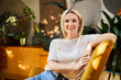 © Westend61 - Relaxed woman sitting on chair at home with indoor plants