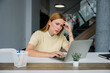 © Westend61 - Overwhelmed woman with laptop feeling stressed at modern office desk
