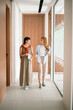 © Westend61 - Colleagues talking and walking in a modern office hallway