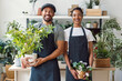 © Westend61 - Entrepreneur and seller with apron holding plants in indoor plant store