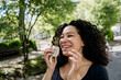 © Westend61 - Smiling woman wiping nose with tissue outdoors on sunny summer day