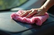 © Vadym - Person polishes car dashboard with fluffy pink microfiber cloth. Hand wipes surface to remove dust and smudges. Auto interior cleaning up close.