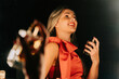 © Westend61 - Smiling woman in red dress applies perfume in front of mirror