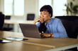 © bnenin - Asian Woman Focused on Laptop in Bright Office Workspace, Professional and Calm Environment