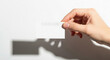 © MstJorina - Hand holding blank white card with faint barcode on clean white background