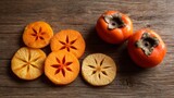 Fresh hachiya persimmon fruit showing whole and sliced kaki on rustic wooden background, autumn healthy eating concept