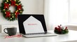 © Tika - Laptop displaying a 'Holidays' message amidst festive Christmas decor and a cozy setting