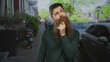 © Krakenimages.com - Young caucasian man with long beard places hand on chin next to parked cars on city street; reflection.