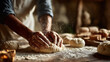 © fannybuddhies - A baker is seen kneading dough on a floured wooden surface, preparing fresh bread in a warm, rustic kitchen, showcasing the traditional art of baking and the simple ingredients used to create.