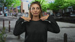 © Krakenimages.com - Woman shielding eyes with hand to forehead on street, palm above brow and standing with one hand on hip; fatigue urban waiting.