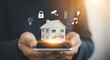 © Pixel Studio - Smart home automation concept featuring a miniature house held over a smartphone surrounded by icons representing security temperature control lighting and entertainment showcasing modern technology