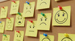 © Pixel Studio - Bulletin board displays yellow sticky notes with various handdrawn facial expressions from happy to sad pinned with colorful pushpins representing mood tracking and emotional awareness in a visual for