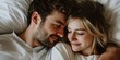 © MNStudio - Young loving couple cuddling in bed in the morning. Young man and woman hugging laying on white sheets. Husband and wife in love.