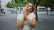 © Krakenimages.com - Woman with hands pressed together praying on a street, head tilted upward and eyes closed; hope prayer.