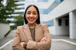 © Geber86 - Adult businesswoman smiling confidently outside modern office