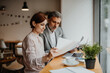 © Halfpoint - Woman showing project to client during business meeting in a coffee shop.