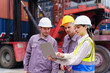 © DG PhotoStock - Container yard staff inspecting and coordinating cargo operations.