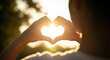 © phj.domingos - Hands forming a heart shape with the sun shining through, love and happiness concept