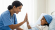 © PRASANNAPIX - A smiling Indian nurse in blue scrubs gives a high-five to a happy little girl patient, creating a moment of care and encouragement in a hospital room.