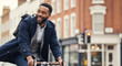 © Atmospheres - Happy Black professional man commuting on a bicycle in the city, enjoying an eco-friendly urban lifestyle.