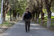 © Midea  - A man is walking down a path in a park