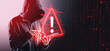 © ImageFlow - Hacker in hoodie using tablet with digital warning sign and bina