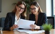 © zhao - Two female executives discussing documents on a meeting at boardroom. High quality