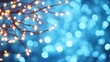 © Arfa_Media - Illuminating festive fairy lights creating warm glowing bokeh dots with copy space against a cool blue abstract backdrop