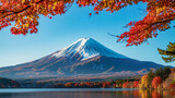 Iconic mount fuji with snow cap viewed across a calm lake framed by autumn foliage