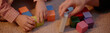 © Seventyfour - Header of child and adult playing with colorful wooden blocks on carpet, hands arranging and stacking shapes together, family spending evening at home, close up of interaction