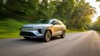 © Let it be - Dynamic front side view of a modern silver electric SUV driving fast on an asphalt forest road during golden hour sunset with motion blur effect