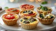 © hjra - Mini quiches with various fillings on a plate