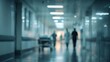 © Punnn - Hospital Corridor with Medical Professionals: A blurred scene captures the hushed activity of a hospital corridor, with silhouettes of doctors and medical staff, and an empty gurney.