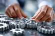 © YouraPechkin - Hands adjusting metal gears on a reflective surface in a workshop environment