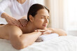 © Anastasiya - Young female enjoying body massage at spa, eyes closed and resting on towel. Soft lighting and calm atmosphere emphasize beauty, wellness care and a peaceful, soothing lifestyle moment