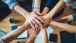 © Tasnim - Diverse group of hands stacked together in a circle on a wooden table