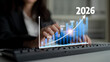 © InfiniteFlow - A business professional interacts with a computer while analyzing projected financial growth from 2023 to 2026, visualizing trends for successful decision-making. Tessel