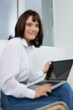 © SHOTPRIME STUDIO - A blurred professional woman sits with a laptop in a modern office, working remotely. Soft light and calm atmosphere highlight focus and productivity.