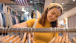 © ChayTee - Young teen tourist Gen Z asia female choose look at zero waste eco go green buy second hand sale store flea market thrift old used vintage fabric style. Happy woman city asian people small retail shop