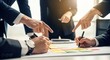 © Mostofa - Business team collaborating and pointing at strategy on a table
