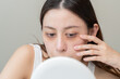 © Pormezz - Bored, insomnia asian young woman, girl looking at mirror hand touching under eyes with problem of black circles or panda puffy, swollen and wrinkle on face. Sleepless, sleepy healthcare person.