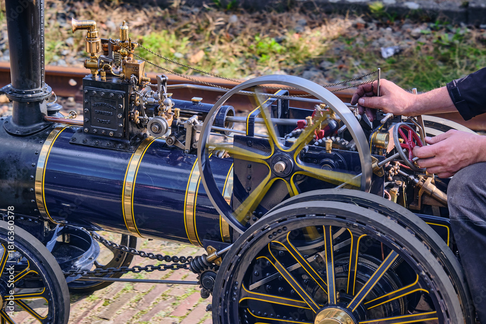 A detailed model steam engine with intricate accents shown with moving ...