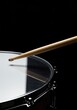 © chaiwat - A wooden drumstick poised above the taut, reflective skin of a professional percussion instrument, ready for rhythmic impact ,concert ,performance ,kit