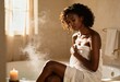 © Anna - A woman wrapped in a towel relaxing by a steamy bath with a candle. Self-care and wellness routine at home. Tranquil spa moment in warm sunlight
