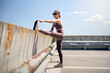 © Rob Wilkinson - sporty woman doing a leg stretch outside