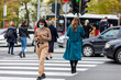 © Jelena - Woman wearing face mask crossing street using phone