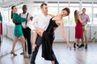 © JackF - Adult couples spin to rumba rhythm during a group dance lesson for beginners