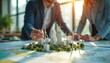 © Pete - Engineers collaborate on sustainable city design. Analyze model featuring wind turbines solar panels. Professionals discuss energy efficiency urban planning strategies for eco-friendly building