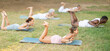 © JackF - Smiling fit young girl performing Dhanurasana, or Bow Pose, lying on yoga mat on green glade in summer park during group yoga class with sporty men and women of different nationalities