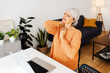 © Xavier Lorenzo - Tired stressed mature businesswoman suffering from neck pain working on laptop at home. Overworked senior middle aged lady massaging neck feeling hurt pain from sedentary job